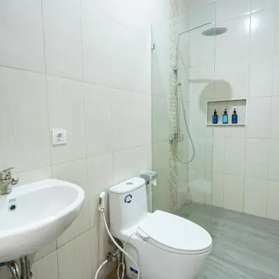 a bathroom with a toilet and a sink and a shower at The Lavana Nakula Villa Kuta Sunset in Kuta