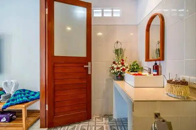 a kitchen with a wooden door next to a counter at Arts Tamansari Villa Two-Bedroom Private Pool Kuta in Kerobokan