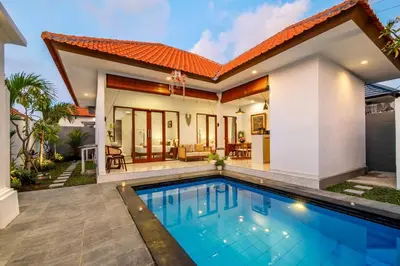 a villa with a swimming pool and a house at Arts Tamansari Villa Two-Bedroom Private Pool Kuta in Kerobokan