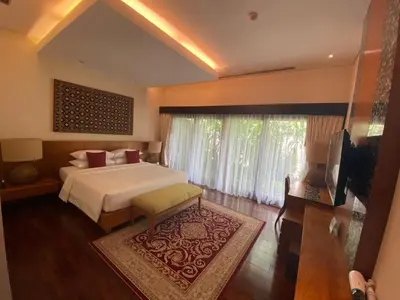 a bedroom with a bed and a large window at Bintang Bali Villa in Kuta