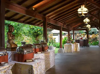 a pavilion with tables with a statue of a woman at Bintang Bali Villa in Kuta