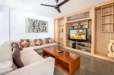 a living room with a couch and a tv at Villa Lilja in Seminyak