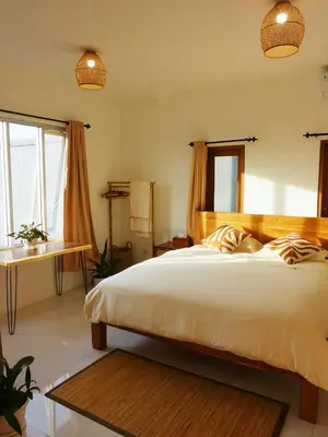 a bedroom with a bed and a desk and windows at Vee Surf in Canggu