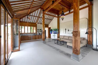 a living room with a couch and a table at Sunset Joglo Pool Villa in Kerobokan