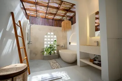a bathroom with a white tub and a sink at Sueño Villa Seminyak in Seminyak