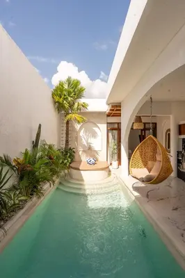 an indoor pool in a house with a swimming pool at Sueño Villa Seminyak in Seminyak