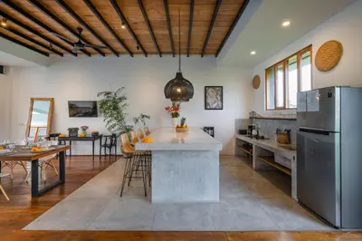 a kitchen with a large island in the middle of a room at Villa Jannu by DreamAwayBali in Seminyak