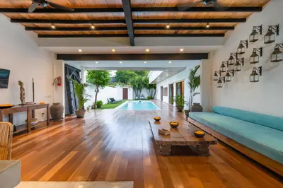 a living room with a blue couch and a table at Villa Jannu by DreamAwayBali in Seminyak