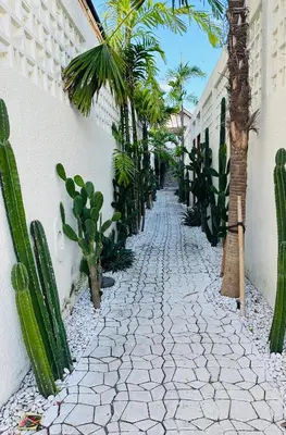 a cobblestone alley with palm trees and a building at Balimac Villa 3 in Seminyak