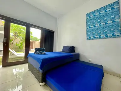 a bedroom with a blue bed and a window at Family Villa with Private Pool in Central Seminyak in Seminyak