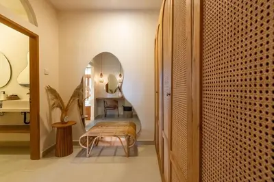 a hallway with an archway and a chair in a room at Wayang Villa by Betterplace in Kerobokan