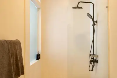 a shower with a shower head in a bathroom at Wayang Villa by Betterplace in Kerobokan