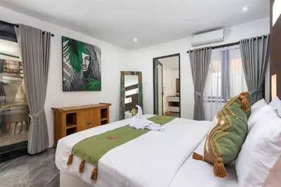 a bedroom with a large bed and a mirror at Villa Julietta, 4 BR in the heart of Seminyak in Seminyak