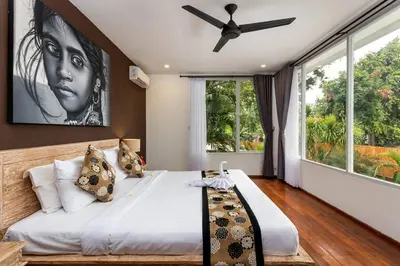 a bedroom with a large bed with a ceiling fan at Villa Julietta, 4 BR in the heart of Seminyak in Seminyak