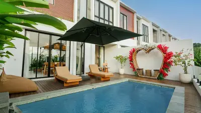 a patio with a swimming pool and an umbrella at Sunset D1 Villa by Betterplace in Kerobokan