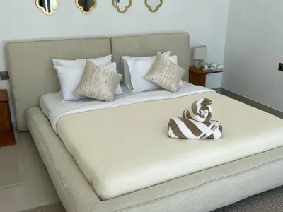 a bed with a dog sitting on top of it at LUX 3 Bedroom Villa 5min Walk to the Beach in Canggu