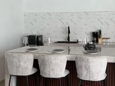a kitchen with a counter with four bar stools at Nomadic LUX villa in Canggu