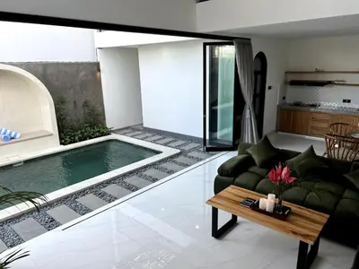 a living room with a pool and a couch and a table at LUX Villa, Private Pool Berawa in Canggu
