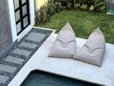 a pair of pillows sitting on a patio at LUX Villa, Private Pool Berawa in Canggu