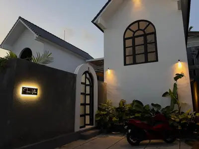 a scooter parked in front of a white house at LUX Villa, Private Pool Berawa in Canggu