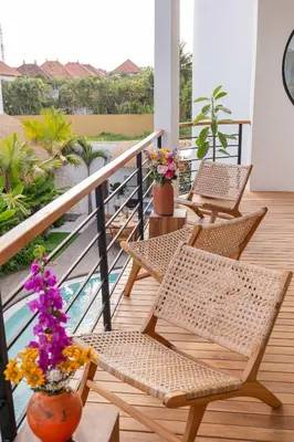 a porch with chairs and flowers on a balcony at Luxury 4BD Villa Casa Diplomatico with Private Pool in Seminyak