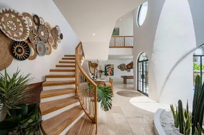 a staircase in a home with wooden floors and white walls at Luxury 4BD Villa Casa Diplomatico with Private Pool in Seminyak
