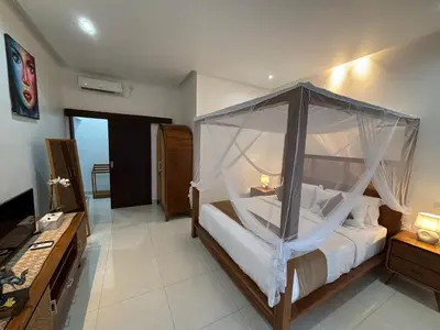a bedroom with a bed with a mosquito net at Private Villa Fabian - Lap pool - Seminyak in Seminyak