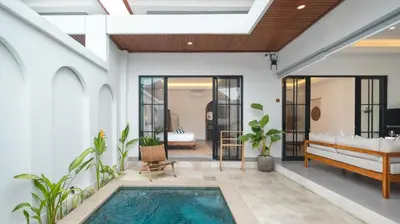 a pool in the middle of a room with a house at Kamila Villa 2 by Villa Finder in Seminyak
