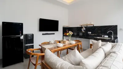 a living room with a white couch and a table at Kamila Villa 2 by Villa Finder in Seminyak