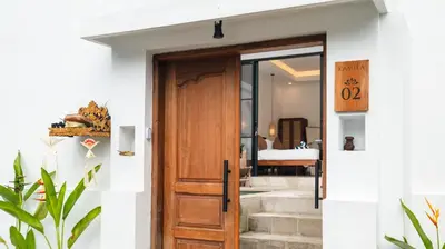 a door leading to a bedroom with a bed at Kamila Villa 2 by Villa Finder in Seminyak