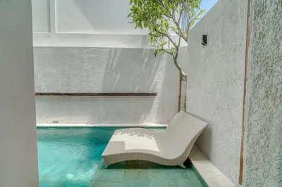 a white chair sitting next to a swimming pool at Nirvana Villa 3BR Brand New in Umalas, Canggu in Kerobokan