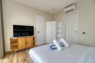 a bedroom with a large bed and a tv at Nirvana Villa 3BR Brand New in Umalas, Canggu in Kerobokan