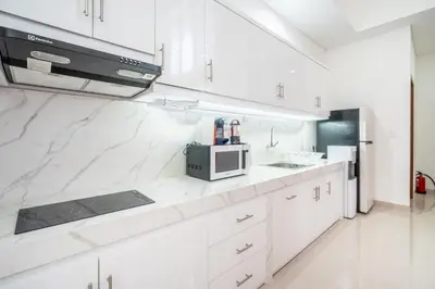 a kitchen with white cabinets and a microwave at Brand new luxury minimalistic villa The Toy with 3 bedrooms in Kerobokan