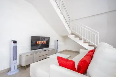 a living room with a white couch and red pillows at Brand new luxury minimalistic villa The Toy with 3 bedrooms in Kerobokan