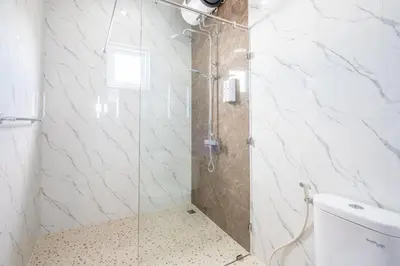 a shower with a glass door in a bathroom at Brand new luxury minimalistic villa The Toy with 3 bedrooms in Kerobokan