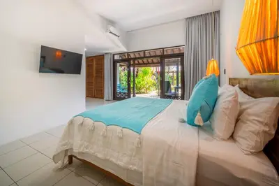 a bedroom with a bed with a blue stuffed animal on it at Villa Nyumpene in Legian in Legian