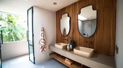 a bathroom with two sinks and two mirrors at Villa Gabrielle in Seminyak
