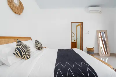 a bed with a black and white blanket on it at Ageta Villa 3 bedrooms Umalas with pool in Kerobokan