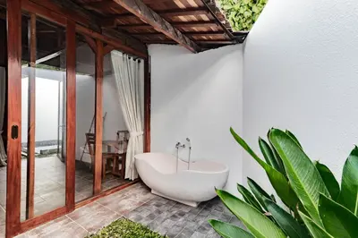 a bathroom with a bath tub and a table at Cendani Private Pool Villa Bali in Kuta