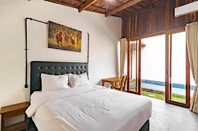 a bedroom with a bed with a view of the ocean at Cendani Private Pool Villa Bali in Kuta