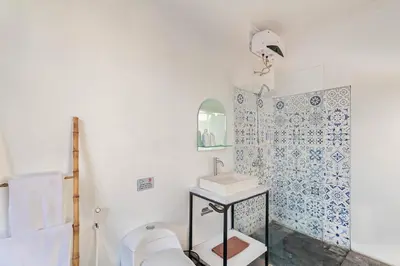 a white bathroom with a toilet and a sink at Cendani Private Pool Villa Bali in Kuta
