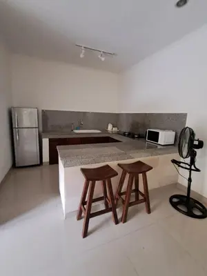 a kitchen with two wooden stools and a counter top at SURFARIS INN on poppies 2 apartment in Legian