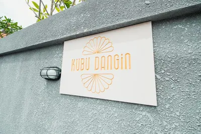a sign on the side of a building at Kubu Dangin Guest House Kerobokan in Seminyak