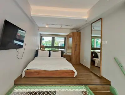 a bedroom with a large bed and a television at HŌM Coliving Bali in Kerobokan