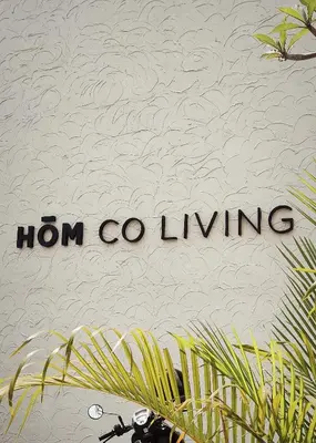 a sign that reads iron coining next to plants at HŌM Coliving Bali in Kerobokan