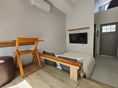 a bedroom with a bed and a tv on the wall at HŌM Coliving Bali in Kerobokan