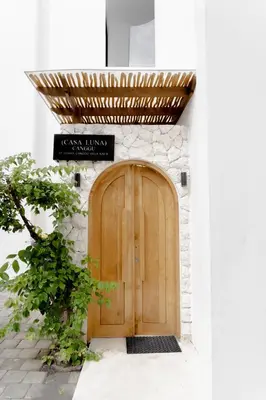 a wooden door on a building with a sign above it at Casa Luna Villa in Kerobokan