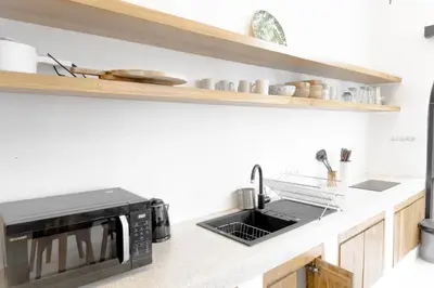 a kitchen with a microwave and a sink at Casa Luna Villa in Kerobokan