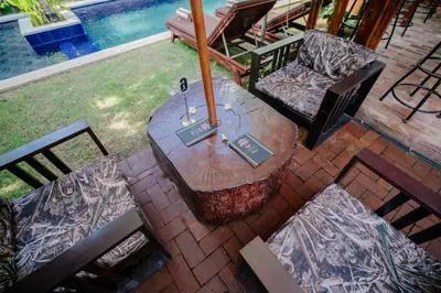 a patio with a table and chairs and a pool at The Saharah Mirage Bali in Kuta