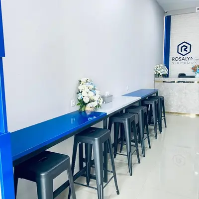 a row of blue tables and stools in a room at Rosalyne Sleepbox Denpasar Bali in Seminyak